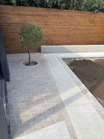 Wentworth Landscaping Limestone Patio with Granite Sett Detail, Olive Tree and Horizontal Fence